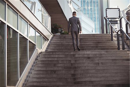 simsearch:6109-08805120,k - Businessman with a diary climbs up stairs Stock Photo - Premium Royalty-Free, Code: 6109-08830049