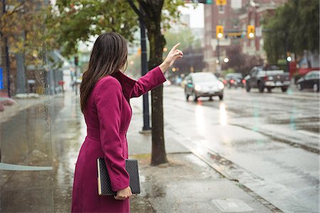 Businesswoman hailing a taxi cab Photographie de stock - Premium Libres de Droits, Code: 6109-08830080