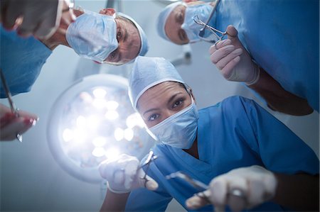 simsearch:6109-08830024,k - Group of surgeons performing operation in operation room Foto de stock - Sin royalties Premium, Código: 6109-08830001