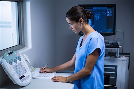 simsearch:6109-08830024,k - Nurse taking notes in x-ray room Foto de stock - Sin royalties Premium, Código: 6109-08830023