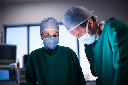 simsearch:6109-08720095,k - Surgeons performing operation in operation theater Stock Photo - Premium Royalty-Free, Code: 6109-08830143