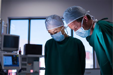 simsearch:6109-08720095,k - Surgeons performing operation in operation theater Stock Photo - Premium Royalty-Free, Code: 6109-08830142