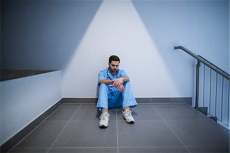 simsearch:6109-08689539,k - Tensed male nurse sitting in corridor Stock Photo - Premium Royalty-Free, Code: 6109-08830157