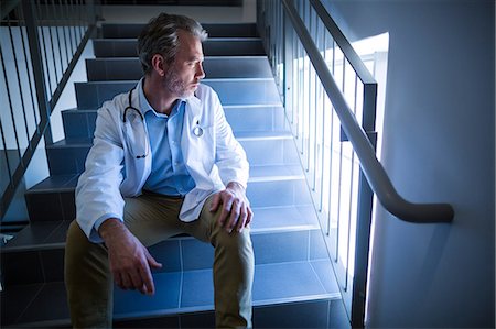 simsearch:400-07334526,k - Thoughtful doctor sitting on staircase Photographie de stock - Premium Libres de Droits, Code: 6109-08830155