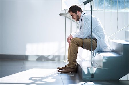 probleme - Sad doctor sitting on staircase Foto de stock - Sin royalties Premium, Código: 6109-08830158