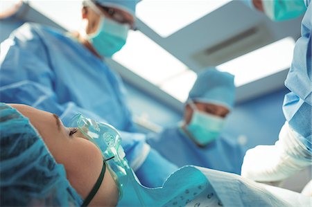 female patient oxygen - Team of surgeons performing operation in operation theater Photographie de stock - Premium Libres de Droits, Code: 6109-08830167