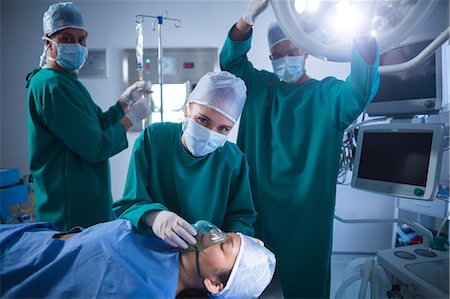 simsearch:6109-08689539,k - Surgeons adjusting oxygen mask on patient mouth in operation theater Stock Photo - Premium Royalty-Free, Code: 6109-08830116