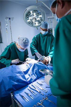 simsearch:6109-08829999,k - Surgeons performing operation in operation theater Foto de stock - Sin royalties Premium, Código: 6109-08830120