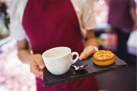simsearch:6109-08928615,k - Mid-section of waitress holding a cup of coffee and snacks Photographie de stock - Premium Libres de Droits, Code: 6109-08830398