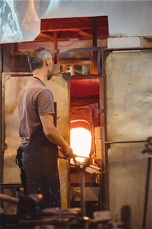 simsearch:400-06796868,k - Glassblower heating a glass in glassblowers oven Stock Photo - Premium Royalty-Free, Code: 6109-08830311