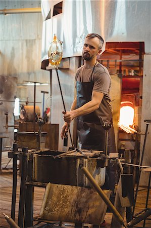 Glassblower shaping a molten glass Stock Photo - Premium Royalty-Free, Code: 6109-08830317