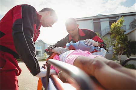 Paramedic giving oxygen to injured girl Stock Photo - Premium Royalty-Free, Code: 6109-08830449