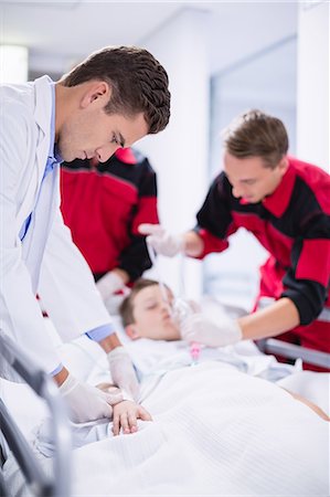 doctor team patient - Doctors adjusting oxygen mask while rushing the patient in emergency room Stock Photo - Premium Royalty-Free, Code: 6109-08830401