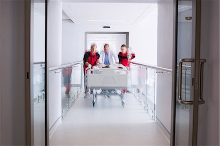 doctor with patient kids bed - Doctors pushing emergency stretcher bed in corridor Stock Photo - Premium Royalty-Free, Code: 6109-08830402