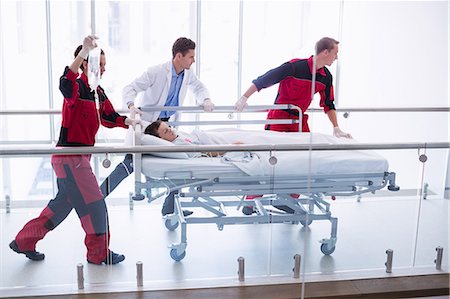 Doctors pushing emergency stretcher bed in corridor Stock Photo - Premium Royalty-Free, Code: 6109-08830407