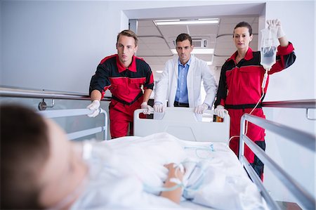 Doctors pushing emergency stretcher bed in corridor Fotografie stock - Premium Royalty-Free, Codice: 6109-08830405