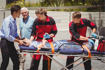 female in on oxygen mask for breathe - Paramedics examining injured boy Stock Photo - Premium Royalty-Free, Code: 6109-08830421