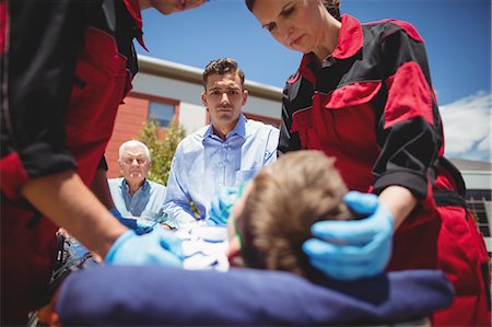 Paramedics examining injured boy Foto de stock - Sin royalties Premium, Código: 6109-08830427