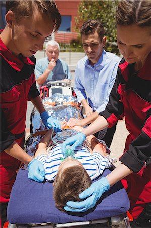 Paramedics examining injured boy Stock Photo - Premium Royalty-Free, Code: 6109-08830426