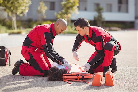 Paramedics putting injured girl onto a backboard Photographie de stock - Premium Libres de Droits, Code: 6109-08830438