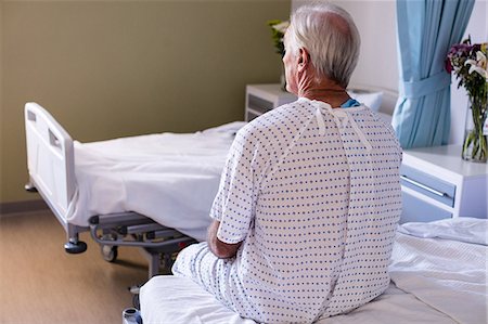 sick men in hospital bed - Thoughtful male senior patient sitting in the ward Stock Photo - Premium Royalty-Free, Code: 6109-08830547