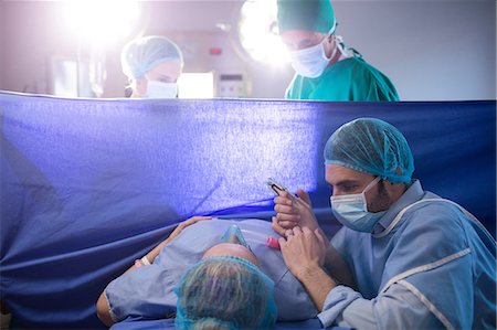 Doctor examining pregnant woman during delivery Stock Photo - Premium Royalty-Free, Code: 6109-08830583