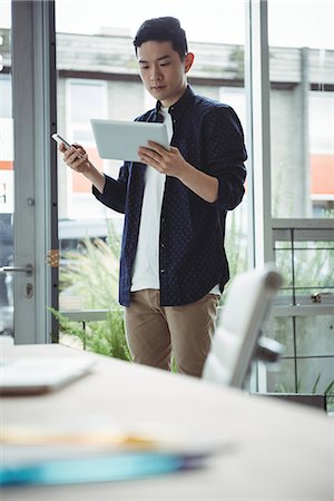 smart casual asian - Business executive using mobile phone and digital tablet Stock Photo - Premium Royalty-Free, Code: 6109-08830759