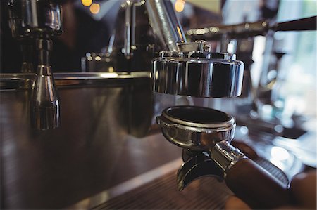 simsearch:649-06622991,k - Waitress holding portafilter filled with ground coffee in cafe Stock Photo - Premium Royalty-Free, Code: 6109-08944143