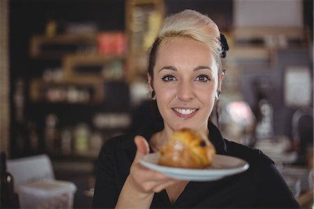 simsearch:6109-08801968,k - Portrait of waitress holding plate with muffin in cafe Photographie de stock - Premium Libres de Droits, Code: 6109-08944164