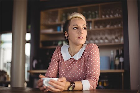 simsearch:6109-08944173,k - Woman holding coffee cup in café Stock Photo - Premium Royalty-Free, Code: 6109-08944165