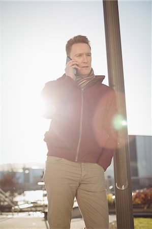 Male executive talking on mobile phone in office premises Stock Photo - Premium Royalty-Free, Code: 6109-08944272