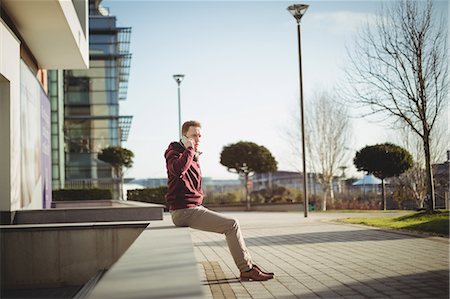 Male executive talking on mobile phone in office premises Stock Photo - Premium Royalty-Free, Code: 6109-08944275