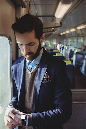 simsearch:6109-08944302,k - Businessman checking time on smartwatch while travelling in train Stock Photo - Premium Royalty-Free, Code: 6109-08944213