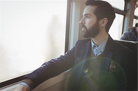 Thoughtful businessman looking out through train window Stock Photo - Premium Royalty-Free, Code: 6109-08944217