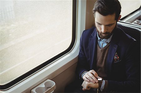 simsearch:6109-08944302,k - Businessman checking time on watch while travelling in train Stock Photo - Premium Royalty-Free, Code: 6109-08944227