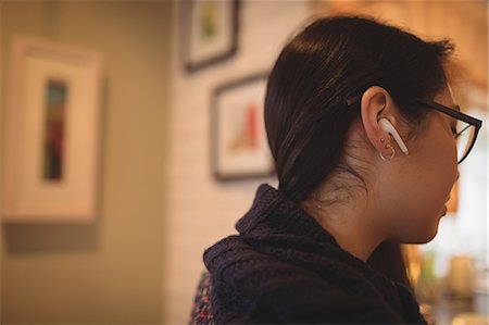 simsearch:614-07652557,k - Woman listening to music with earphones at home Stock Photo - Premium Royalty-Free, Code: 6109-08944358