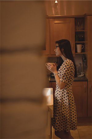 simsearch:6109-06781541,k - Woman having coffee in kitchen at home Stock Photo - Premium Royalty-Free, Code: 6109-08944377