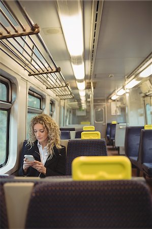simsearch:6109-08944302,k - Young woman using mobile phone inside train compartment Stock Photo - Premium Royalty-Free, Code: 6109-08944315