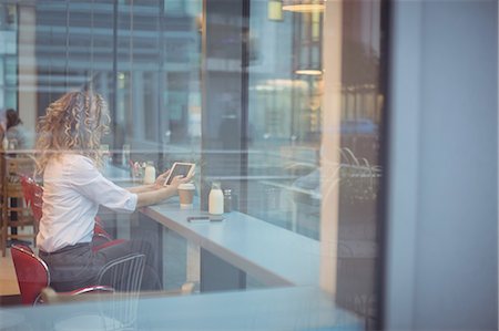 simsearch:400-04322314,k - Woman using digital tablet at counter in cafeteria Stock Photo - Premium Royalty-Free, Code: 6109-08944331