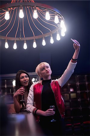 friends at a bar - Smiling friends taking a selfie while having wine in bar Foto de stock - Sin royalties Premium, Código: 6109-08944455