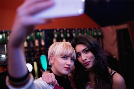 simsearch:6109-08944483,k - Friends posing while taking selfie on mobile phone in bar Stockbilder - Premium RF Lizenzfrei, Bildnummer: 6109-08944456