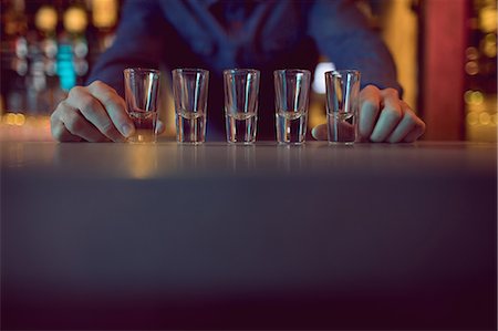 simsearch:6109-08944483,k - Bartender placing shot glasses in a row at counter in bar Stockbilder - Premium RF Lizenzfrei, Bildnummer: 6109-08944462