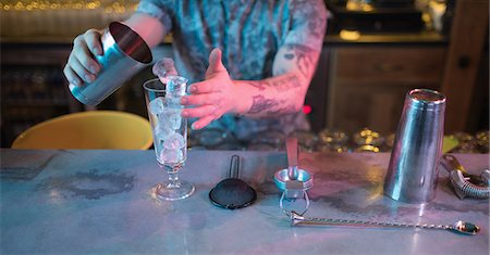 simsearch:824-03722357,k - Bartender preparing a drink at counter in bar Foto de stock - Sin royalties Premium, Código: 6109-08944468