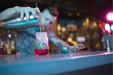 simsearch:6109-08394900,k - Bartender preparing cocktail at counter in bar Foto de stock - Royalty Free Premium, Número: 6109-08944475