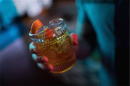 simsearch:6109-08945043,k - Man holding a glass of orange cocktail in bar Foto de stock - Sin royalties Premium, Código: 6109-08944482