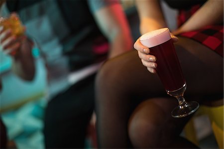 Woman holding a glass of drink in bar Stock Photo - Premium Royalty-Free, Code: 6109-08944487