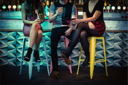 Friends enjoying the drinks at counter in bar Foto de stock - Sin royalties Premium, Código: 6109-08944488