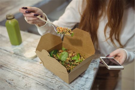 simsearch:649-06352854,k - Mid section of woman using mobile phone while eating salad Stock Photo - Premium Royalty-Free, Code: 6109-08944408