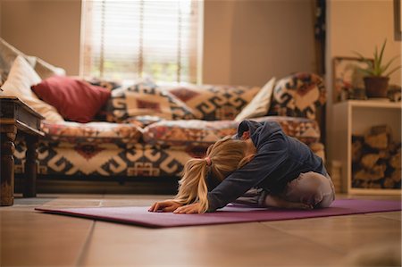 simsearch:649-07585525,k - Girl performing yoga in living room at home Stock Photo - Premium Royalty-Free, Code: 6109-08944548