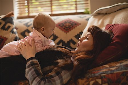 simsearch:6109-08700736,k - Mother playing with her baby on sofa in living room Foto de stock - Sin royalties Premium, Código: 6109-08944568